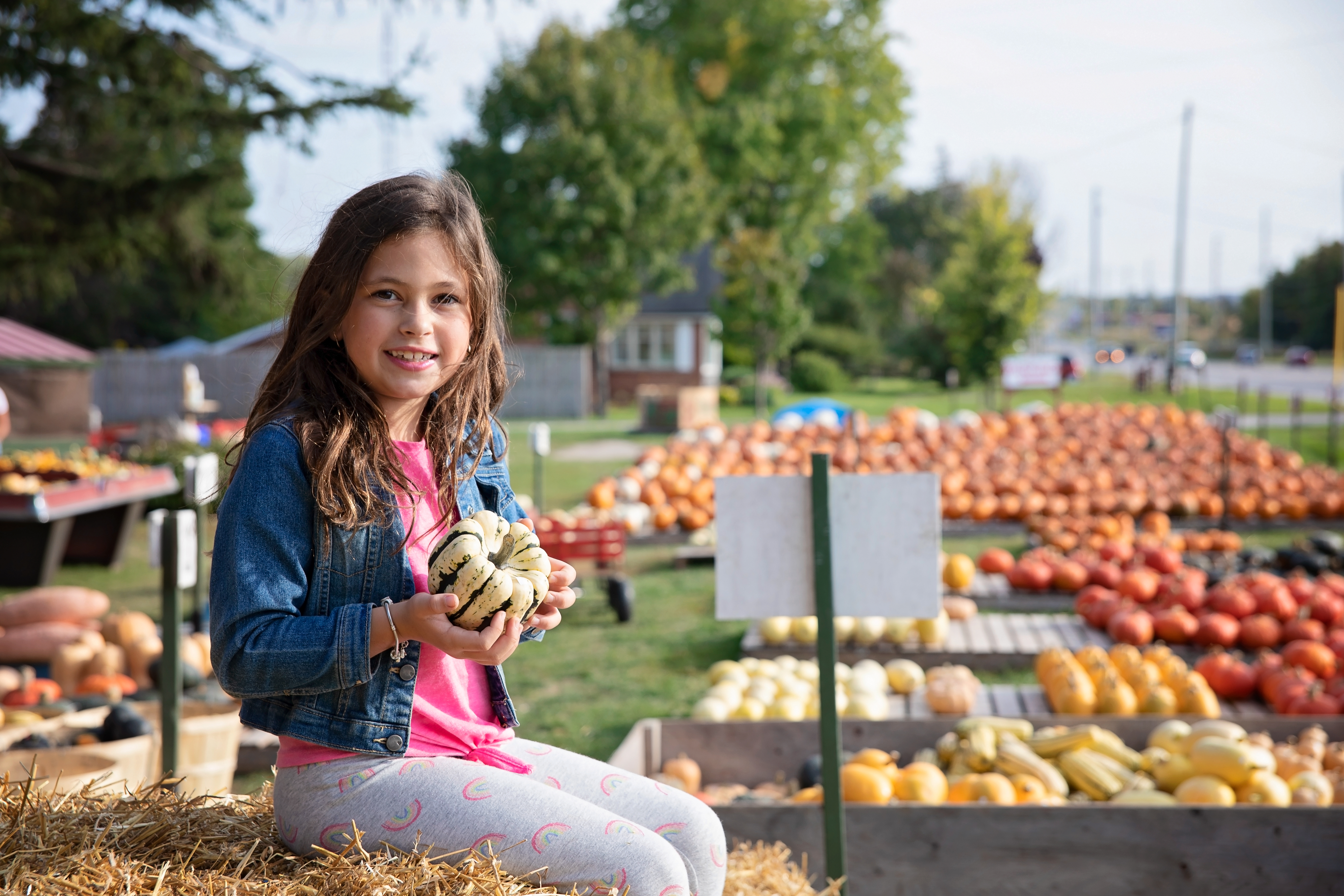 Young girl holding a squash at a farm in Georgina